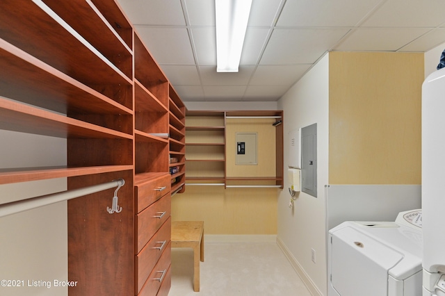 walk in closet with a paneled ceiling, washer and clothes dryer, and electric panel