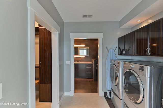 laundry room featuring light tile patterned floors, sink, independent washer and dryer, and cabinets