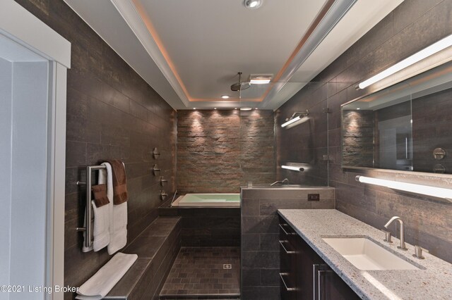 bathroom featuring tile walls, vanity, and shower with separate bathtub