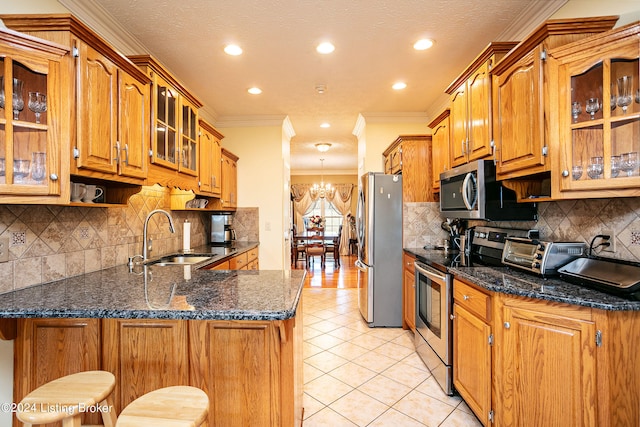 kitchen featuring a kitchen bar, sink, stainless steel appliances, and kitchen peninsula