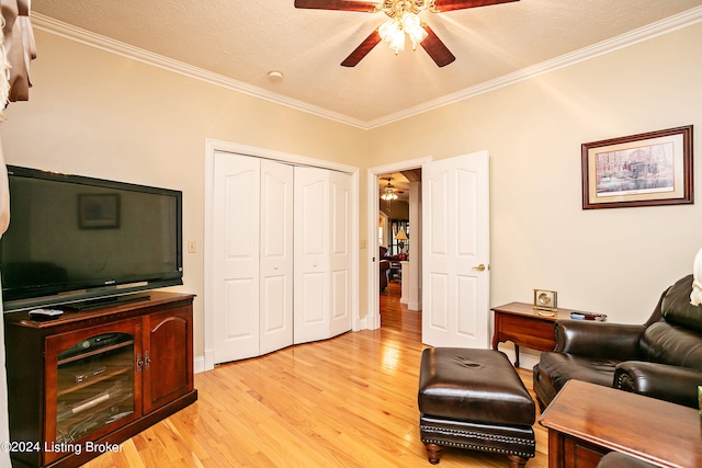 home office with light hardwood / wood-style flooring, ceiling fan, crown molding, and a textured ceiling