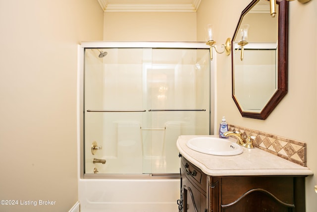 bathroom with bath / shower combo with glass door, vanity, and crown molding