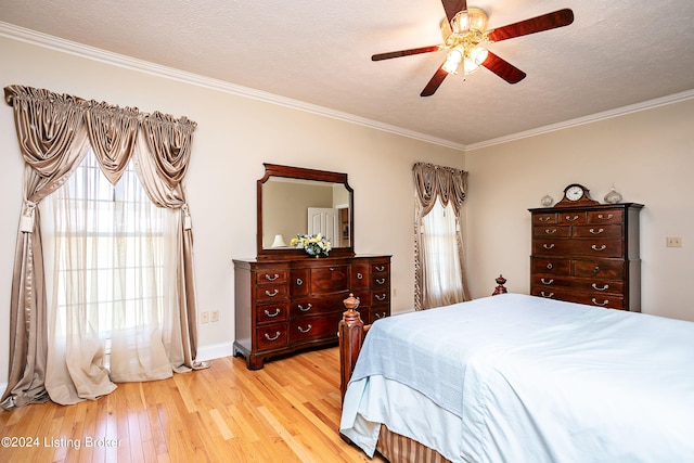 bedroom featuring light hardwood / wood-style flooring, ceiling fan, ornamental molding, and a textured ceiling