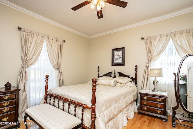 bedroom with a textured ceiling, ornamental molding, ceiling fan, and light hardwood / wood-style flooring