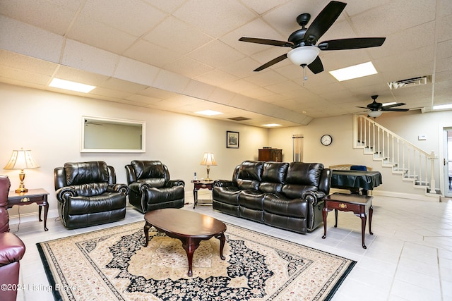 tiled living room featuring ceiling fan and a paneled ceiling