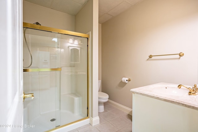 bathroom with vanity, tile patterned flooring, toilet, and a shower with door