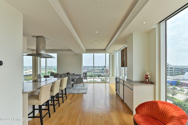 kitchen featuring white cabinets, wine cooler, a tray ceiling, floor to ceiling windows, and light hardwood / wood-style floors