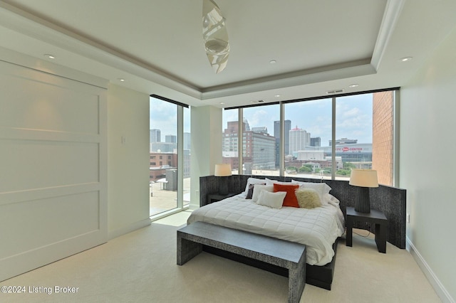 bedroom featuring a tray ceiling, multiple windows, and light colored carpet