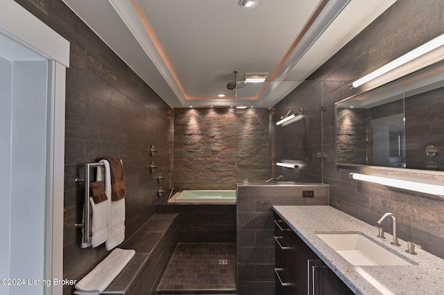 222 E Witherspoon St Unit 703-704, Louisville, KY 40202 - full bathroom with a tray ceiling, tiled shower, vanity, a bath, and tile walls