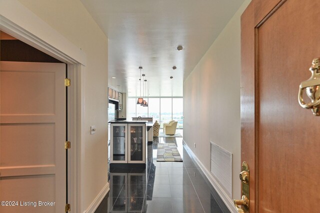 corridor with dark tile patterned floors and wine cooler