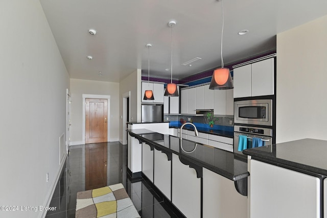 222 E Witherspoon St Unit 703-704, Louisville, KY 40202 - kitchen featuring white cabinetry, dark tile patterned floors, dark countertops, pendant lighting, and appliances with stainless steel finishes