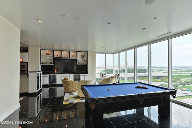 rec room with dark tile patterned floors, billiards, and a wealth of natural light