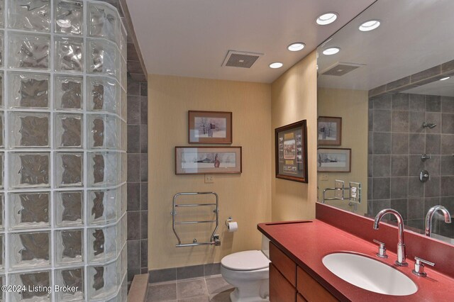 bathroom featuring tile patterned floors, a shower, vanity, and toilet