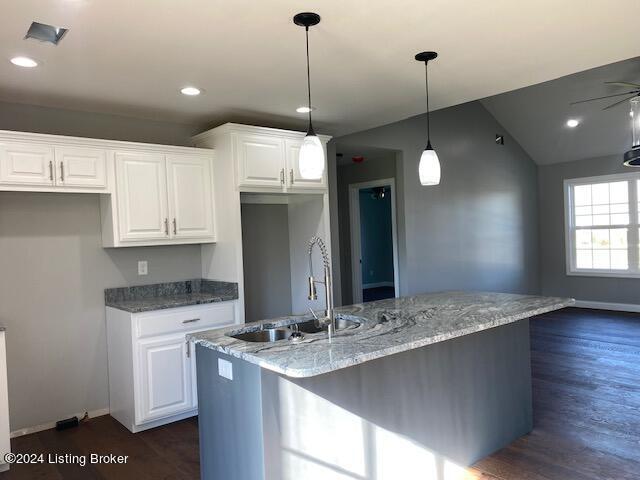 kitchen featuring sink, white cabinets, hanging light fixtures, dark hardwood / wood-style flooring, and light stone countertops