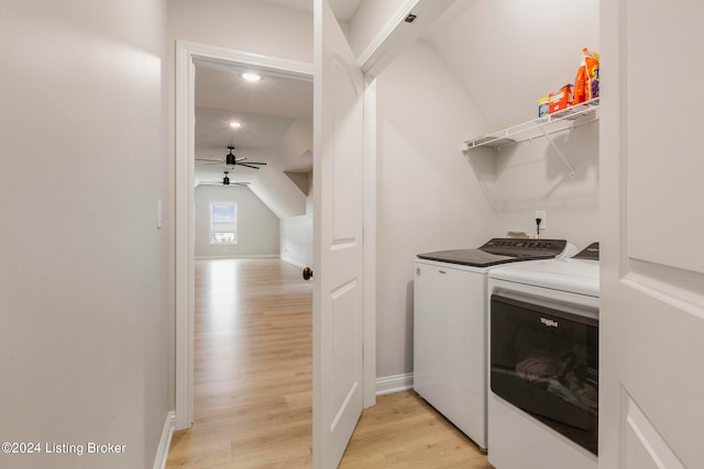 clothes washing area with washing machine and clothes dryer, ceiling fan, and light hardwood / wood-style flooring