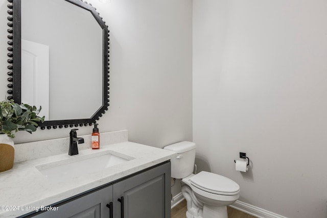 bathroom featuring hardwood / wood-style floors, vanity, and toilet