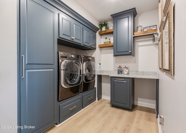 washroom featuring cabinets, light hardwood / wood-style flooring, and washer and dryer