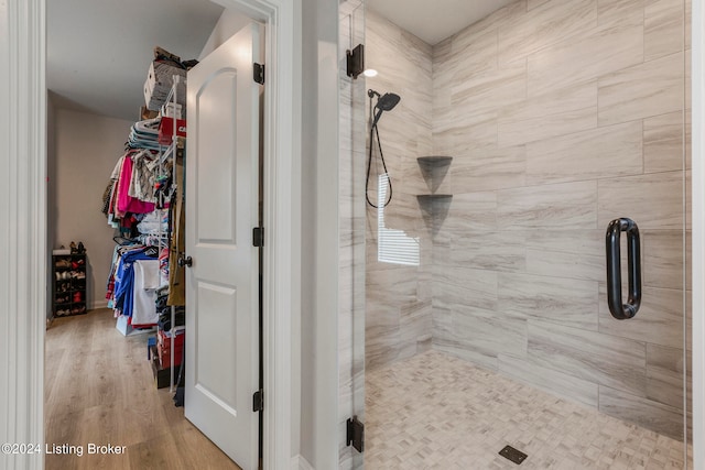 bathroom featuring a shower with door and hardwood / wood-style floors