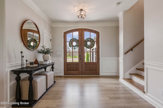 entryway featuring a chandelier, light hardwood / wood-style floors, french doors, and crown molding