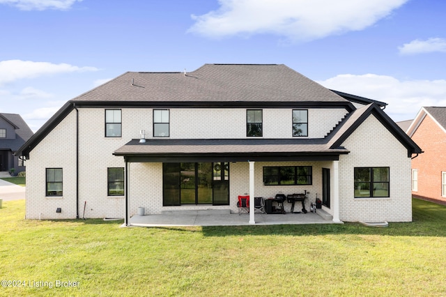 rear view of house with a lawn and a patio area