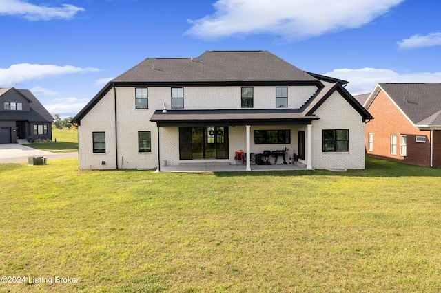 rear view of house featuring a yard, central AC, and a patio area