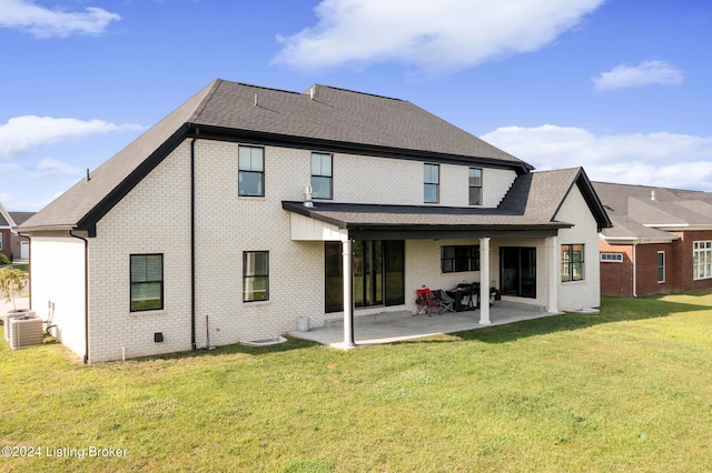 rear view of property with central AC unit, a yard, and a patio area