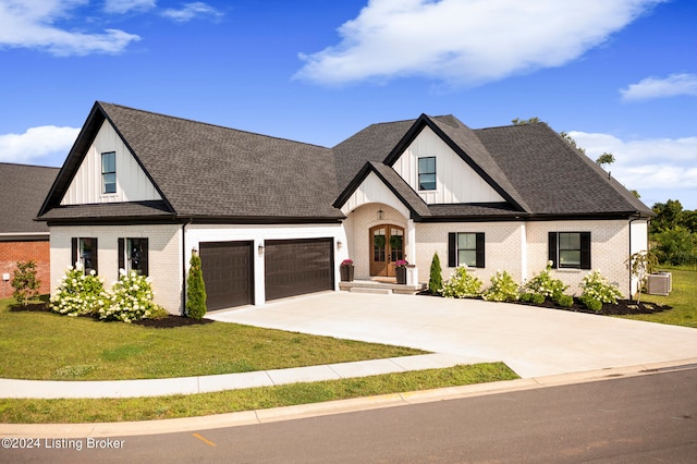 view of front of property featuring a garage, a front lawn, and central AC unit