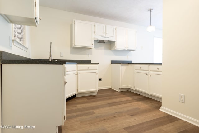 kitchen featuring white cabinetry, hanging light fixtures, and hardwood / wood-style floors