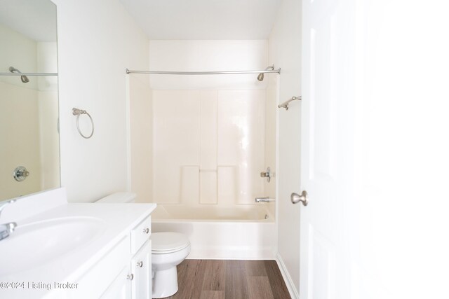 full bathroom featuring washtub / shower combination, wood-type flooring, vanity, and toilet