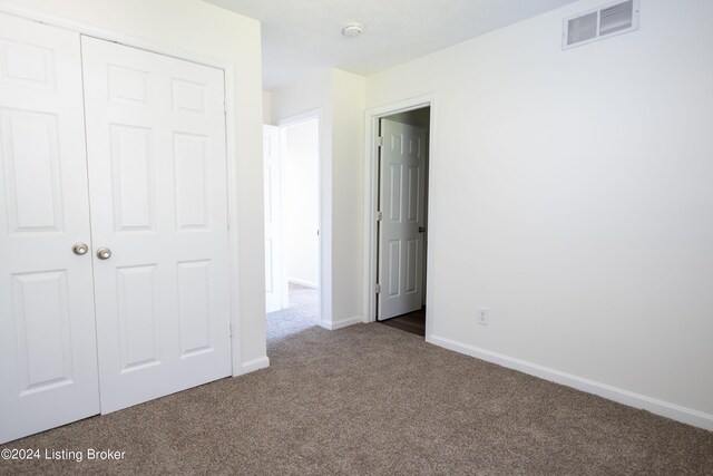 unfurnished bedroom featuring a closet and carpet flooring