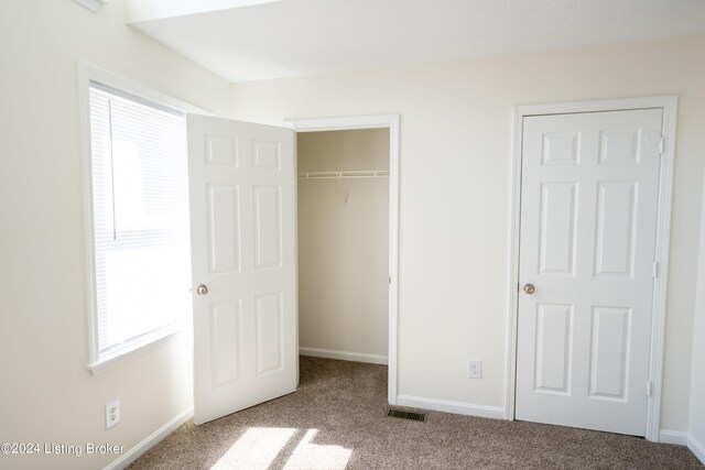 unfurnished bedroom featuring carpet and a closet