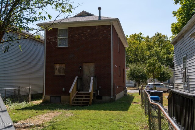 rear view of house featuring a yard