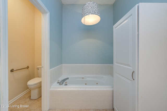 bathroom with tile patterned floors, a relaxing tiled tub, and toilet