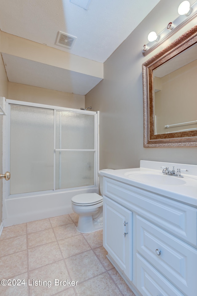 full bathroom with combined bath / shower with glass door, vanity, toilet, and tile patterned floors