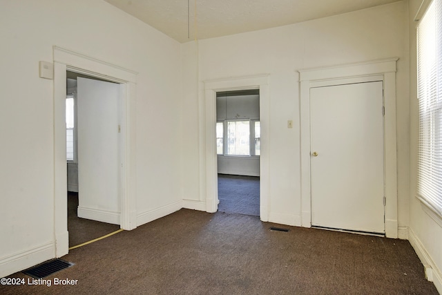 spare room with dark colored carpet