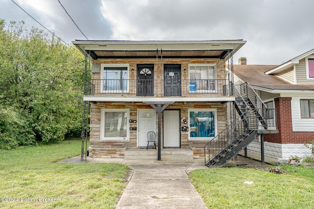 view of front facade featuring a balcony and a front yard