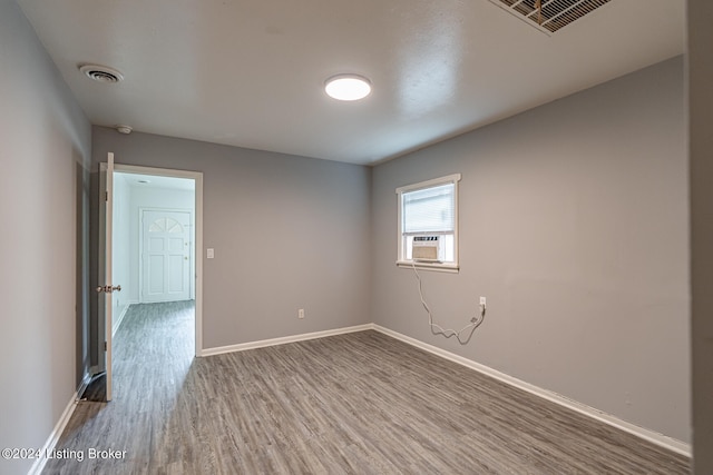 empty room with cooling unit and hardwood / wood-style floors