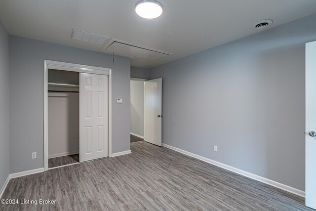 unfurnished bedroom with wood-type flooring and a closet