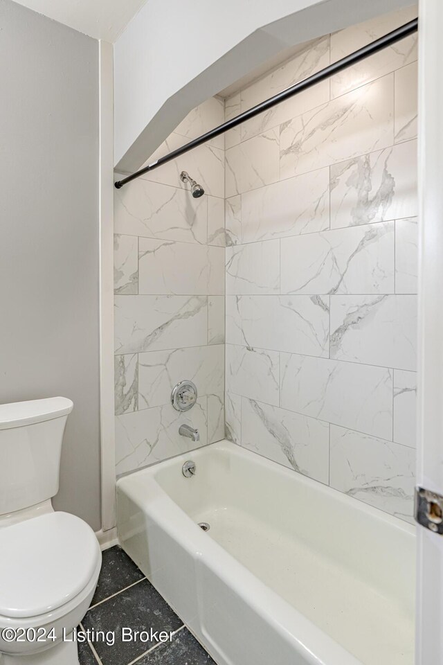 bathroom with tiled shower / bath, tile patterned flooring, and toilet