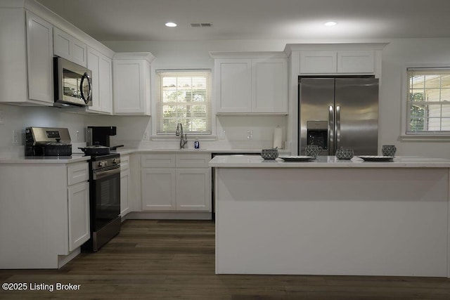 kitchen featuring white cabinetry, sink, stainless steel appliances, and dark hardwood / wood-style floors