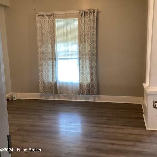 unfurnished room with dark wood-type flooring