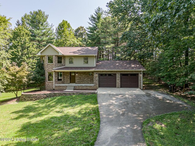 2656 Doe Valley Pkwy, Brandenburg, KY 40108 - view of front of home with driveway, covered porch, roof with shingles, an attached garage, and a front lawn