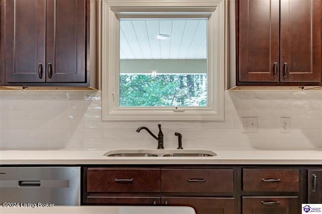 kitchen with backsplash, stainless steel dishwasher, dark brown cabinetry, and sink