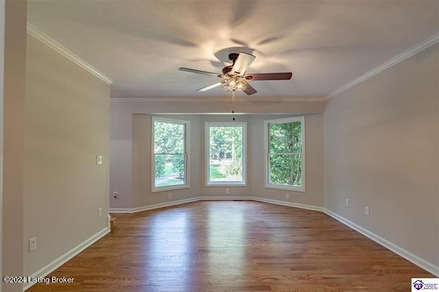 empty room featuring ornamental molding, ceiling fan, and hardwood / wood-style flooring