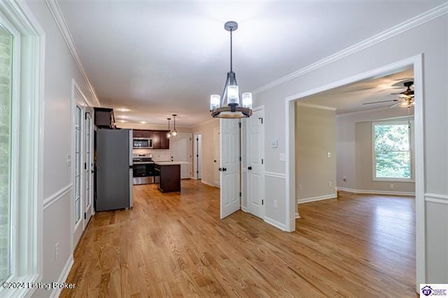 kitchen featuring ornamental molding, a kitchen island, hardwood / wood-style flooring, stainless steel appliances, and ceiling fan with notable chandelier