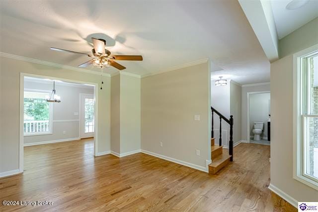 unfurnished room featuring ceiling fan with notable chandelier, light wood-type flooring, and ornamental molding