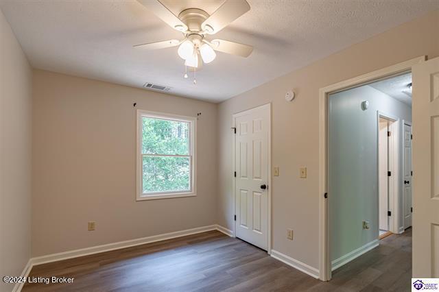 2656 Doe Valley Pkwy, Brandenburg, KY 40108 - unfurnished bedroom featuring wood finished floors, baseboards, ceiling fan, and visible vents