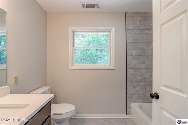 full bathroom with tub / shower combination, tile patterned flooring, vanity, and toilet