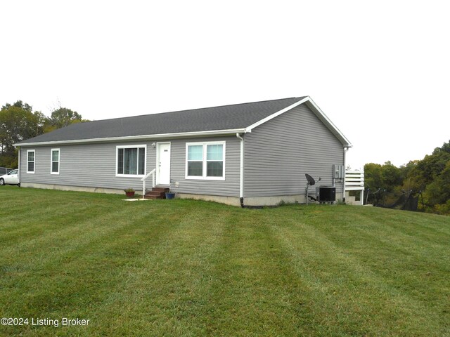 view of front facade featuring central AC unit and a front yard