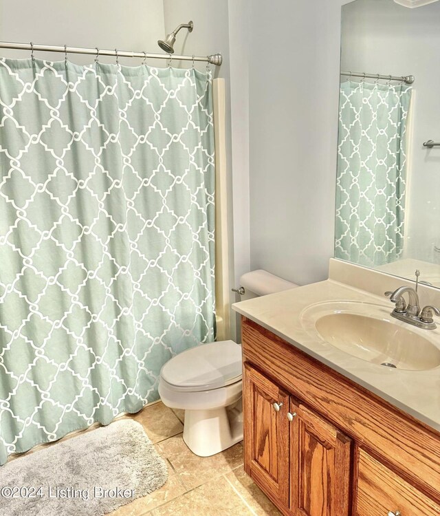 bathroom featuring vanity, a shower with shower curtain, toilet, and tile patterned floors